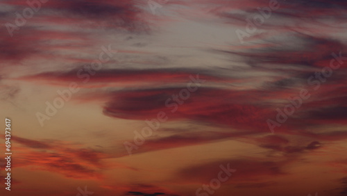 Colorful clouds on summer sunset sky with plane landing