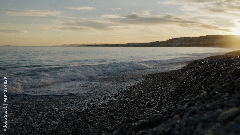 Low angle shot of sunset on a pebble beach of Nice Low angle shot of sunset on a pebble beach of Nice