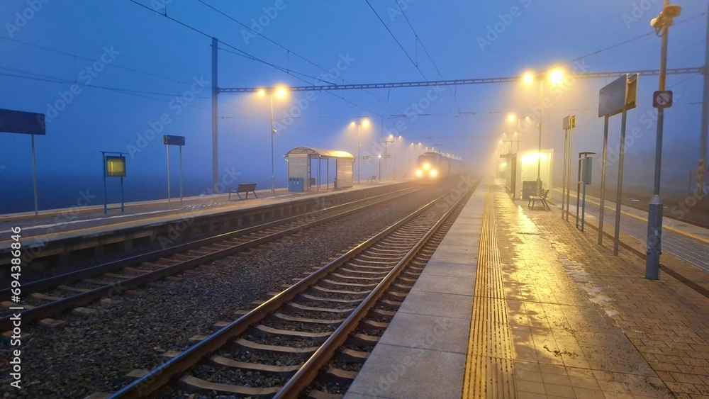 Night railway station. Abandoned railway station in fog. Concept of traveling, tourism or commuting to work