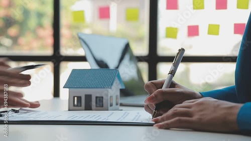 Real estate broker agent being analysis and making the decision a home estate loan to customer to signing contract documents for realty purchase, Bank employees recommend mortgage loan approval. photo
