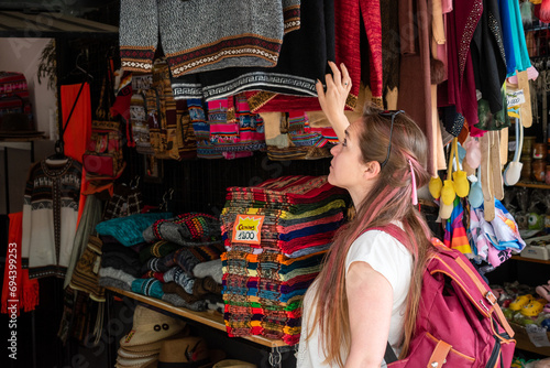 Mujer turista mirando los artículos de una tienda de recuerdos en Salta, Argentina	 photo