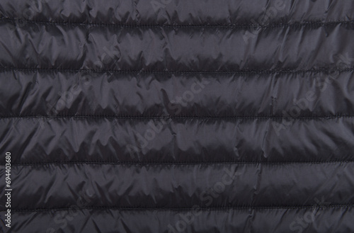 Black fabric of a men's winter jacket as a background, outerwear, jacket.