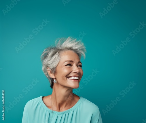 older smiling woman on a turquoise background