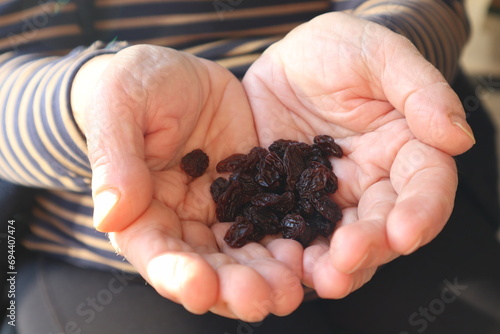 Woman holding dry organic raisins