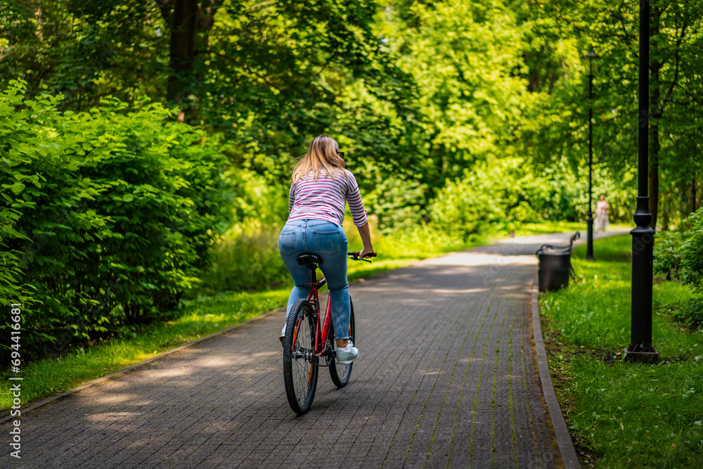 Obraz premium Woman riding bicycle in city park