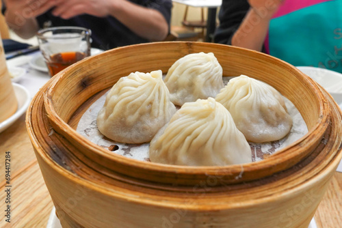 Fotografie 4 xiao long bao in a bamboo steamer