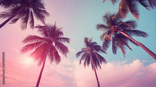 Coconut palm trees on pink sky background. Vintage toned © Ilya