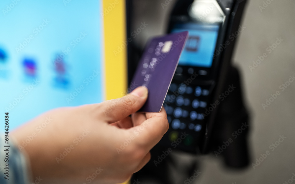 Woman pays with card at a self-service payment terminal. Woman pays with card at a self-service payment terminal.
