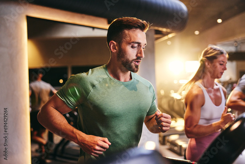 Fit man using a gym treadmill photo