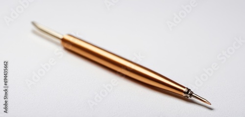  a pen sitting on top of a table next to a piece of paper with a pen sticking out of it.