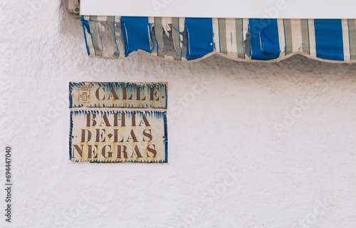 Cartel típico de la calle en Las Negras, Andalucía, España. Nombre de la calle en una señal deslucida por el clima. Bahía de Las Negras street. photo