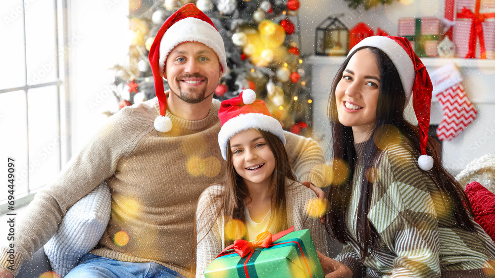 Little girl with her parents and Christmas gift at home Little girl with her parents and Christmas gift at home
