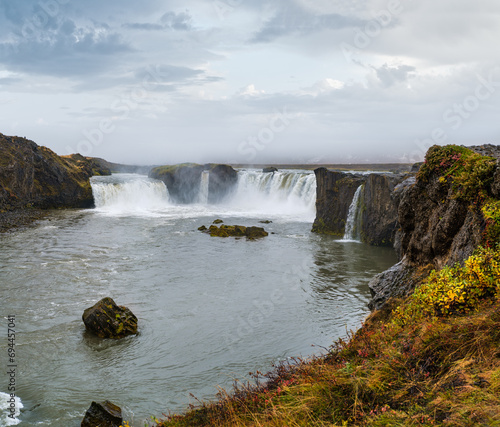 Picturesque full of water big waterfall Godafoss autumn dull day view, north Iceland.
