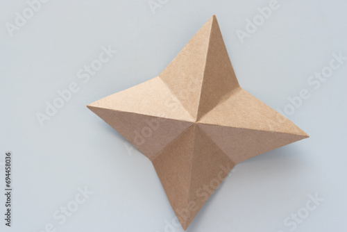 four-pointed origami star object on blank paper