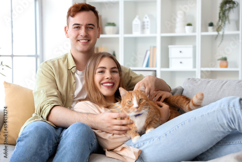 Young couple with cute cat at home © Pixel-Shot