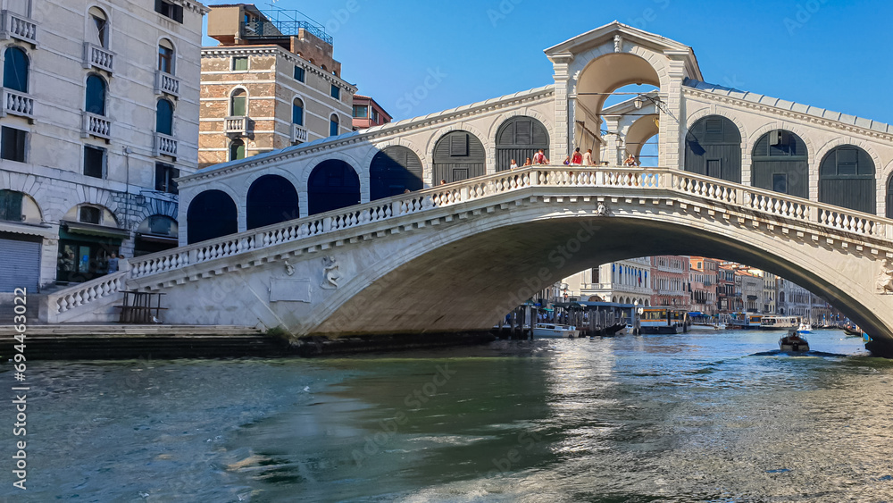 Channel Canal Grande with scenic view of famous Rialto bridge in city of Venice, Veneto, Northern Italy, Europe. Venetian architectural landmarks. Romantic vacation. Summer urban tourism