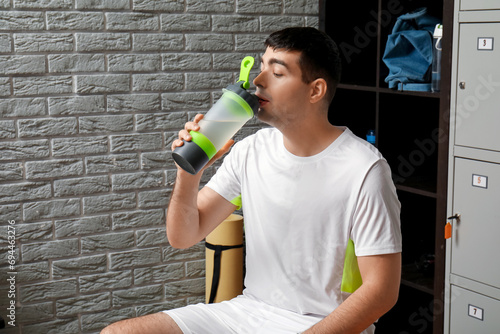 Sporty young man drinking w...