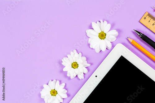 Stationery items and tablet on a purple background, office photo