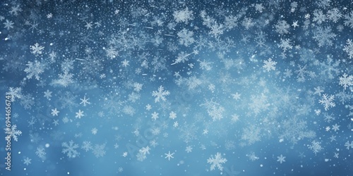 Snow flakes falling from the sky on a blue background. Suitable for winter and holiday-themed designs