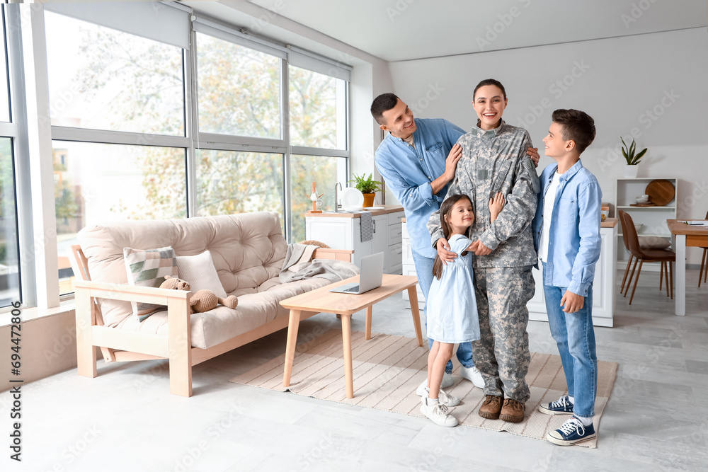 Female soldier with her husband and little children at home