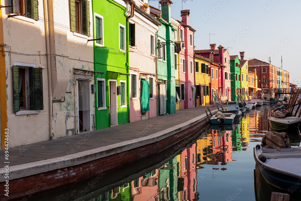Obraz premium Scenic view of bright colorful houses on island of Burano in city of Venice, Veneto, Northern Italy, Europe. Cruising around the Venetian Lagoon. Water canal along idyllic riverbank. Summer tourism