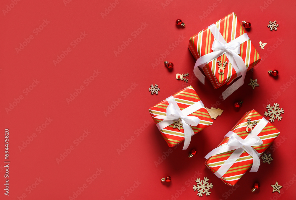 Christmas gift boxes with decor on red background Christmas gift boxes with decor on red background