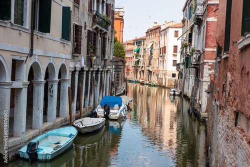 Panoramic view of a water channel in city of Venice  Veneto  Italy  Europe. Venetian architectural landmarks and old houses facades along the man made water traffic corridor. Urban tourism in summer