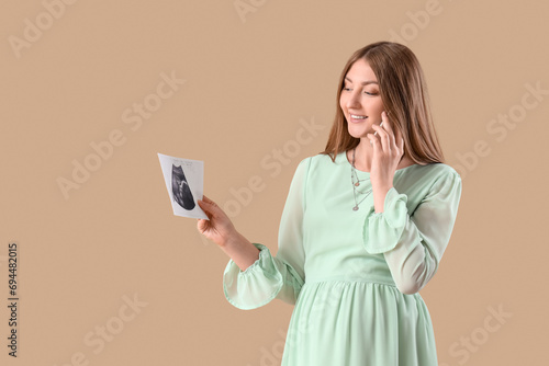 Happy pregnant woman holdin...