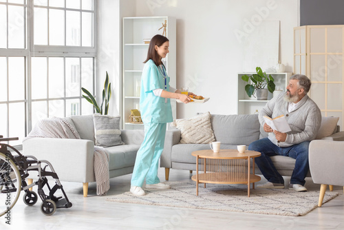 Nurse bringing breakfast to mature man at home