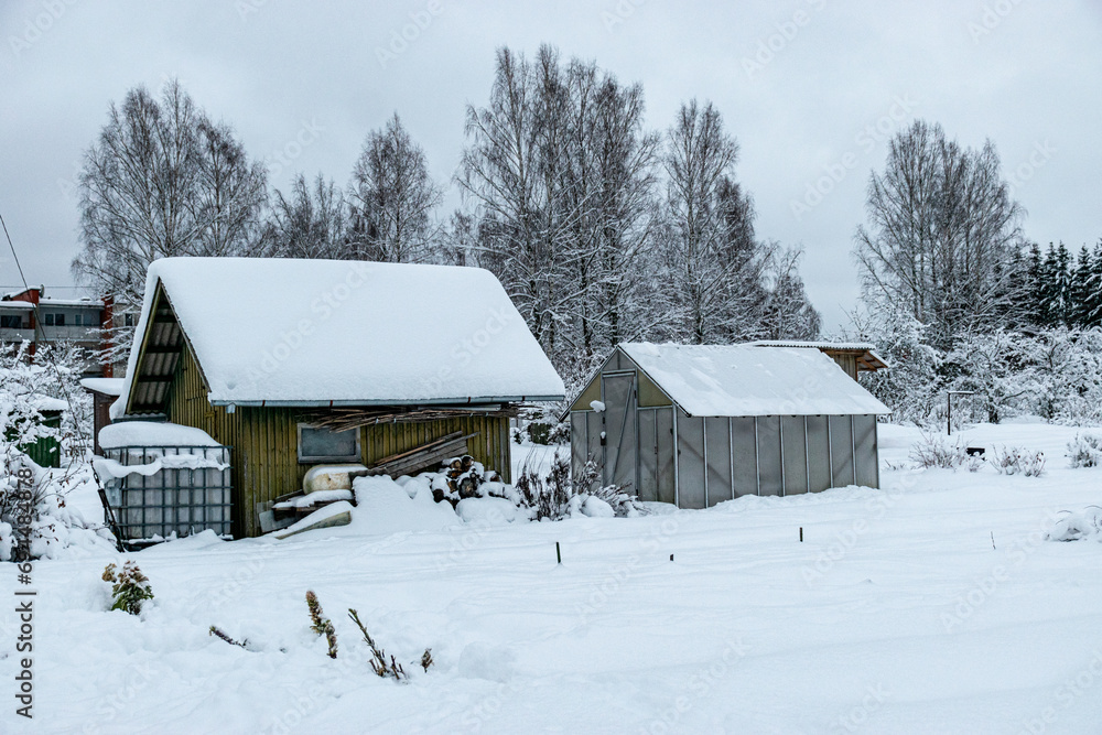 garden in winter, covered with snow, fruit trees, garden house and garden accessories