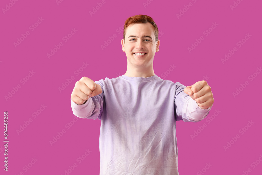 Young man with imaginary steering wheel on purple background Young man with imaginary steering wheel on purple background