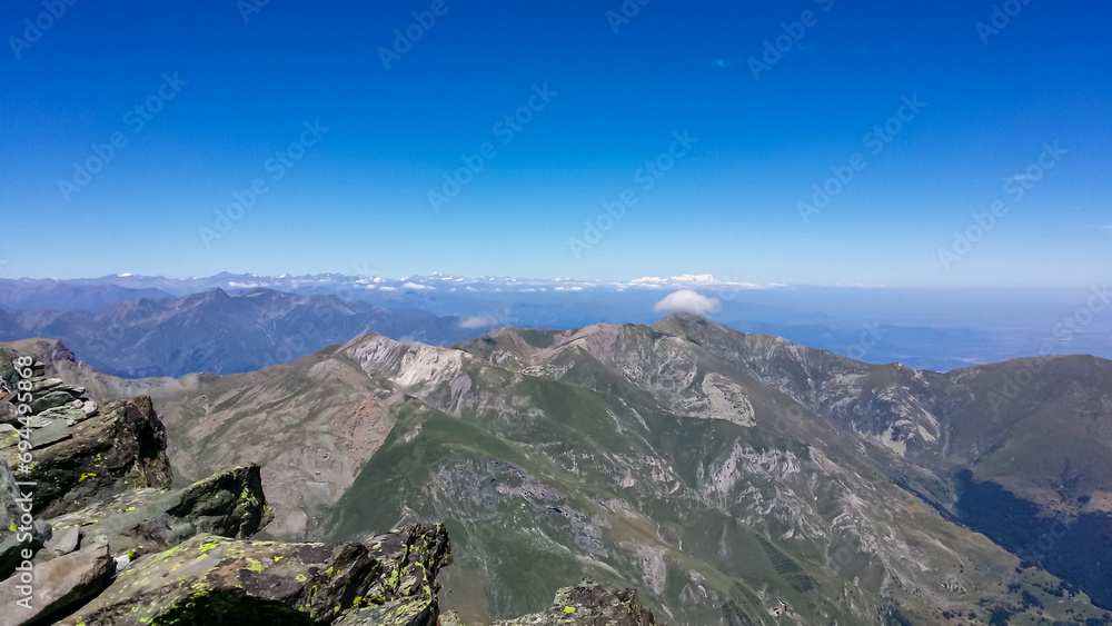 Panoramic view from mountain summit Monte Viso (Monviso) in the Cottian Alps, Cuneo, Piemonte, Italy, Europe. Massive rock walls and ridges of the Stone king. Majestic landscape. Wanderlust, climbing