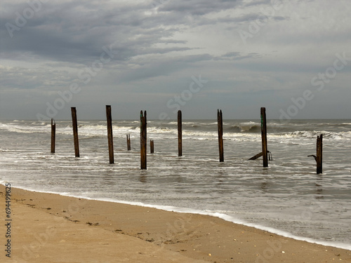 Stark wooden pilings  age unknown  are all that remain of a building subject to years of heavy weather along a shoreline in Marineland  Florida  for motifs of location  climate and the environment