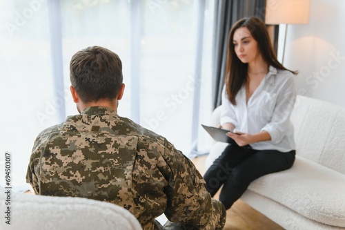 Sad male soldier on appointment with psychologist at office