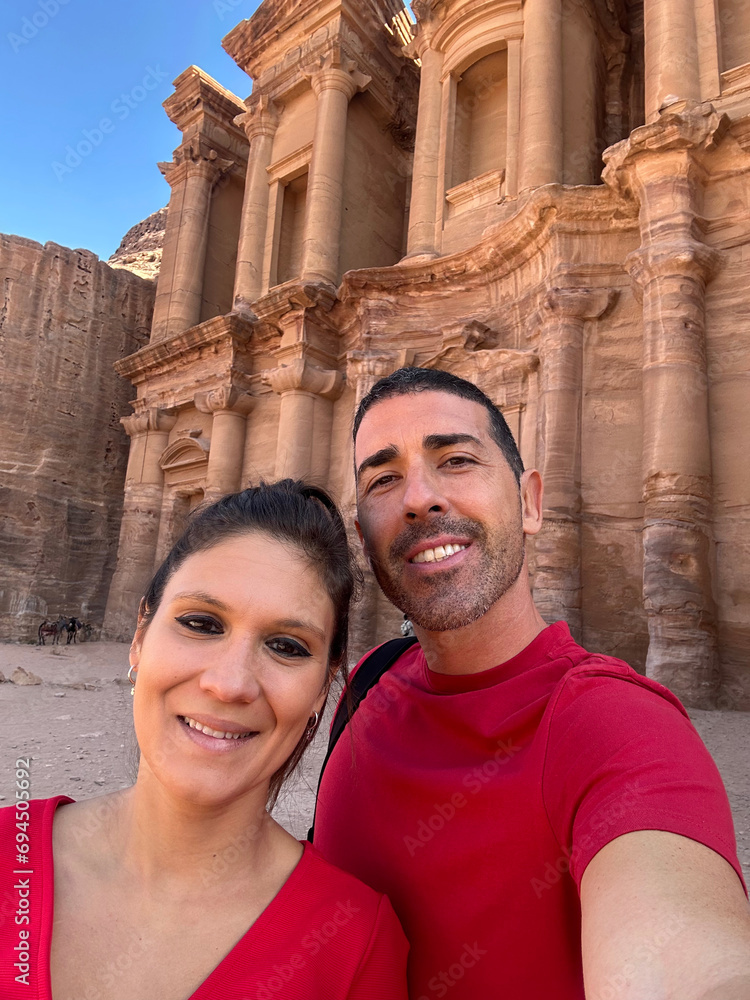 Young European boys taking a selfie next to Petra Monastery. Middle-aged heterosexual couple enjoying the ruins of the city of Petra, Jordan. Young European boys taking a selfie next to Petra Monastery. Middle-aged heterosexual couple enjoying the ruins of the city of Petra, Jordan.