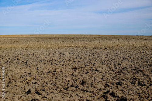This is a photo of a plowed field with a blue sky.