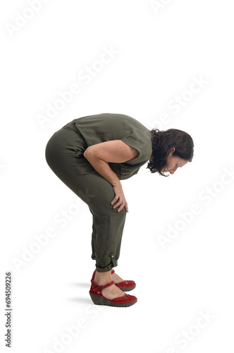 side view of a woman standing looking at the floor searching for something on white background.