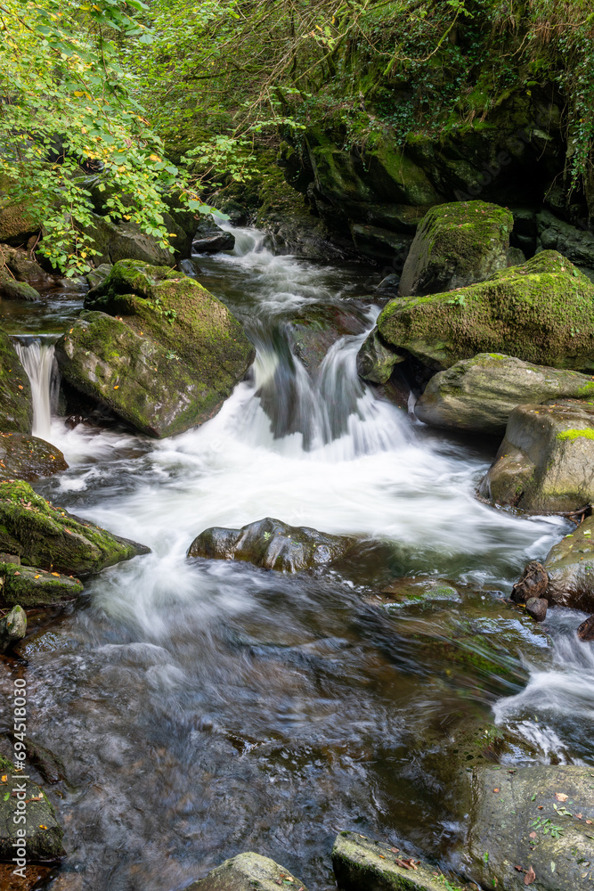 Long exposure of a waterfall on the East Lyn River at Watersmeet in Exmoor National Park Long exposure of a waterfall on the East Lyn River at Watersmeet in Exmoor National Park