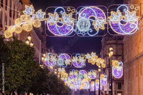 Christmas lights decoration in Constitution Avenue, Avenida de la Constitucion, around Seville Cathedral at christmas time, Selective focus with focus in the first lights line photo
