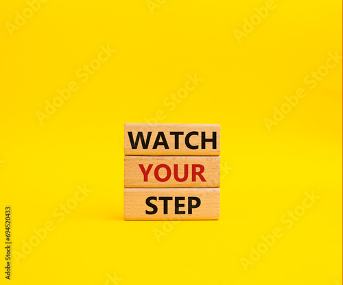 Watch your Step symbol. Concept words Watch your Step on wooden blocks. Beautiful yellow background. Business and Watch your Step concept. Copy space.