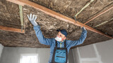 Ceiling insulation. The Worker putting a thermal insulation from glass wool.