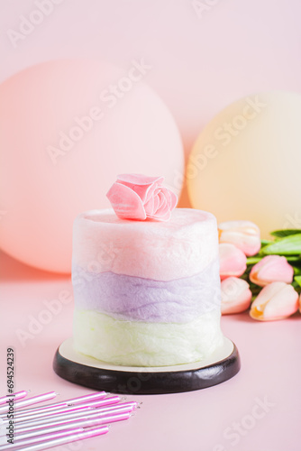 Colored cotton candy cake and party decorations on the table vertical view