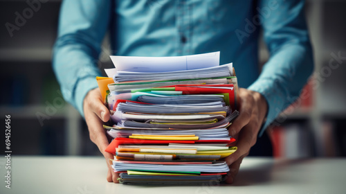 Close-up of a man holding a large stack of documents photo
