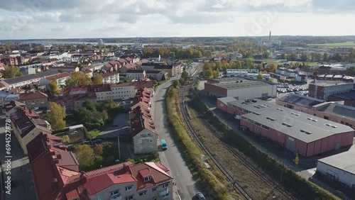 Slowly rising footage over the small Swedish town of Nyköping on a chilly but sunny day next to a road and train tracks