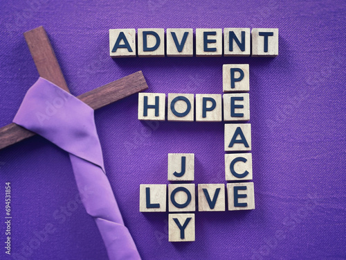 Christianity concept about Advent and Christmas season. ADVENT, HOPE, PEACE, LOVE, JOY written on wooden blocks. With blurred style background.