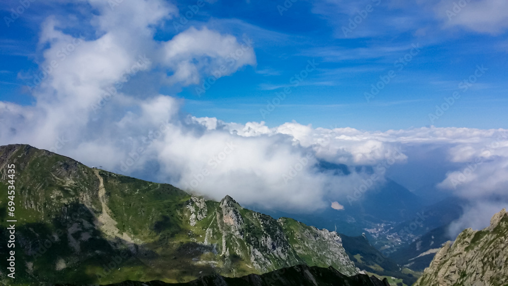 Fototapeta premium Scenic mtb trail along ancient pathway from the Alps to the sea, through the Italian regions of Piemonte and Liguria, and France. Looking at endless mountain ranges and lush green pastures and hills.