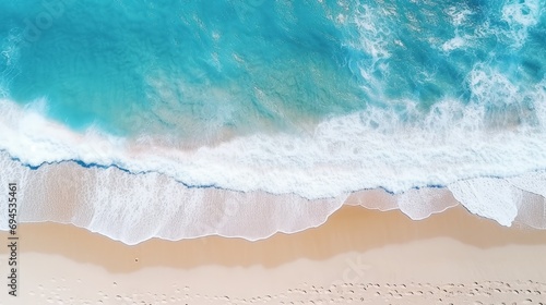 An aerial picture of a sandy beach near the sea with waves, surrounded by a gorgeous stretch of white sand.