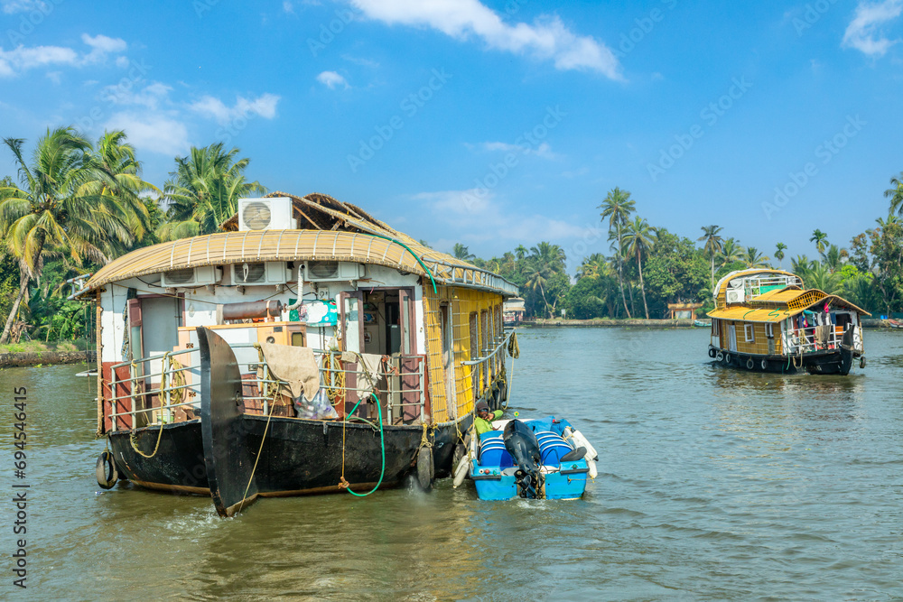 Indian traditional houseboats floating on Pamba river, with palms at the coastline, Alappuzha, Kerala, South India Indian traditional houseboats floating on Pamba river, with palms at the coastline, Alappuzha, Kerala, South India