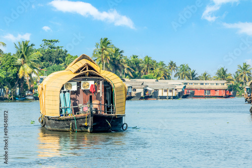 Indian traditional living houseboats floating on Pamba river, with palms at the coastline, Alappuzha, Kerala, South India photo