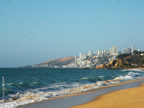 Waves breaking on the shore with view of Concón and Reñaca in the background